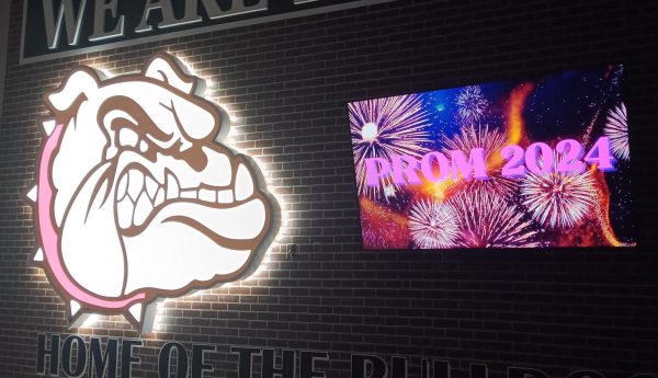 Edmond Memorial bulldog LED sign next to a TV that reads PROM 2024