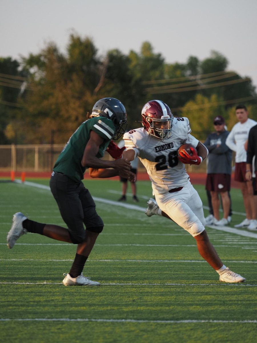 A bulldog swerves past a wolf towards the endzone.