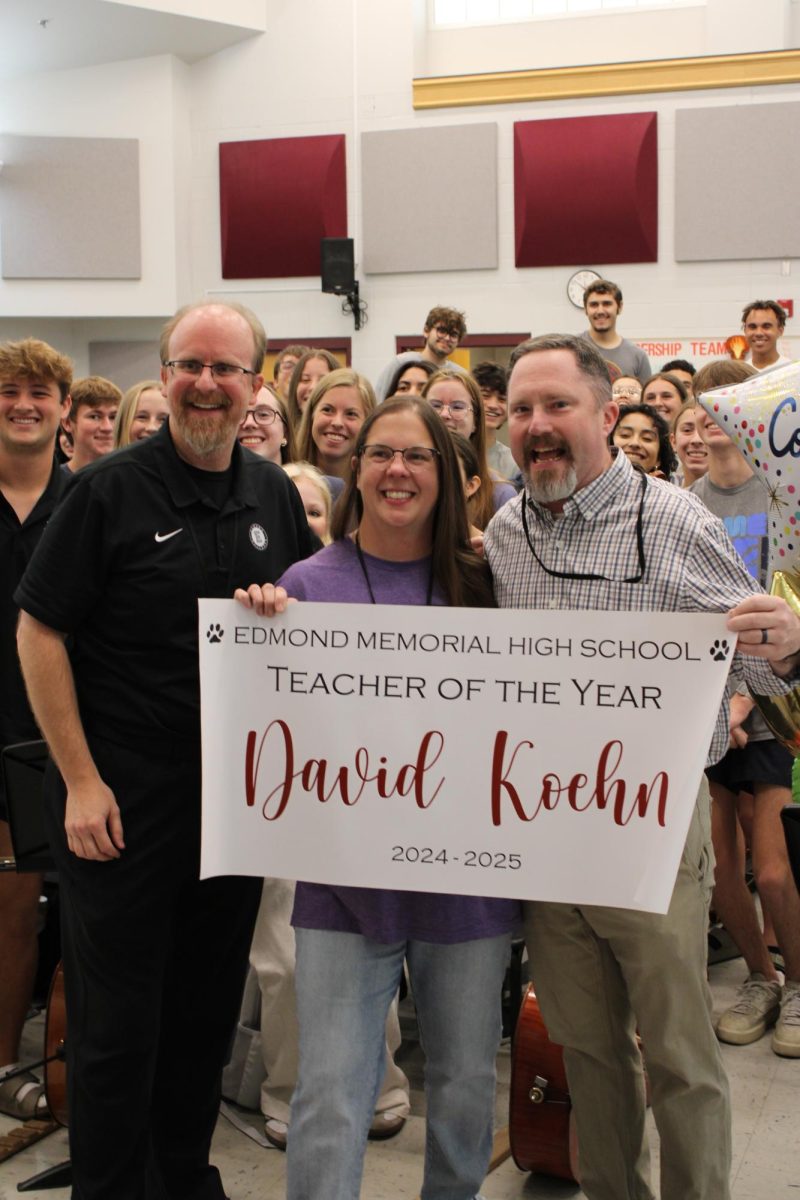 The Teacher of the Year is in excitement and takes a picture with the head principal and some of his students. 