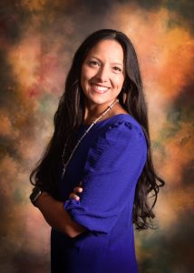 Courtney Tsotigh dressed in her native clothing, posing for a picture. 