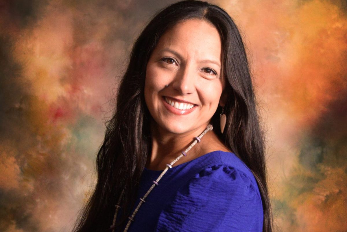 Courtney Tsotigh dressed in her native clothing, posing for a picture. 