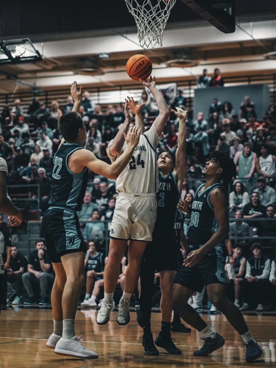 Junior DJ Pedulla shoots the basketball as three Edmond North players surround him.