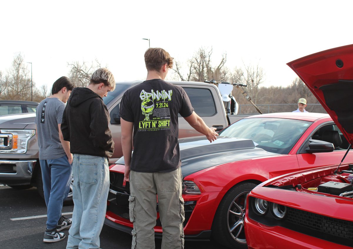 Attendees view a Mustang at the Swine Week car show.