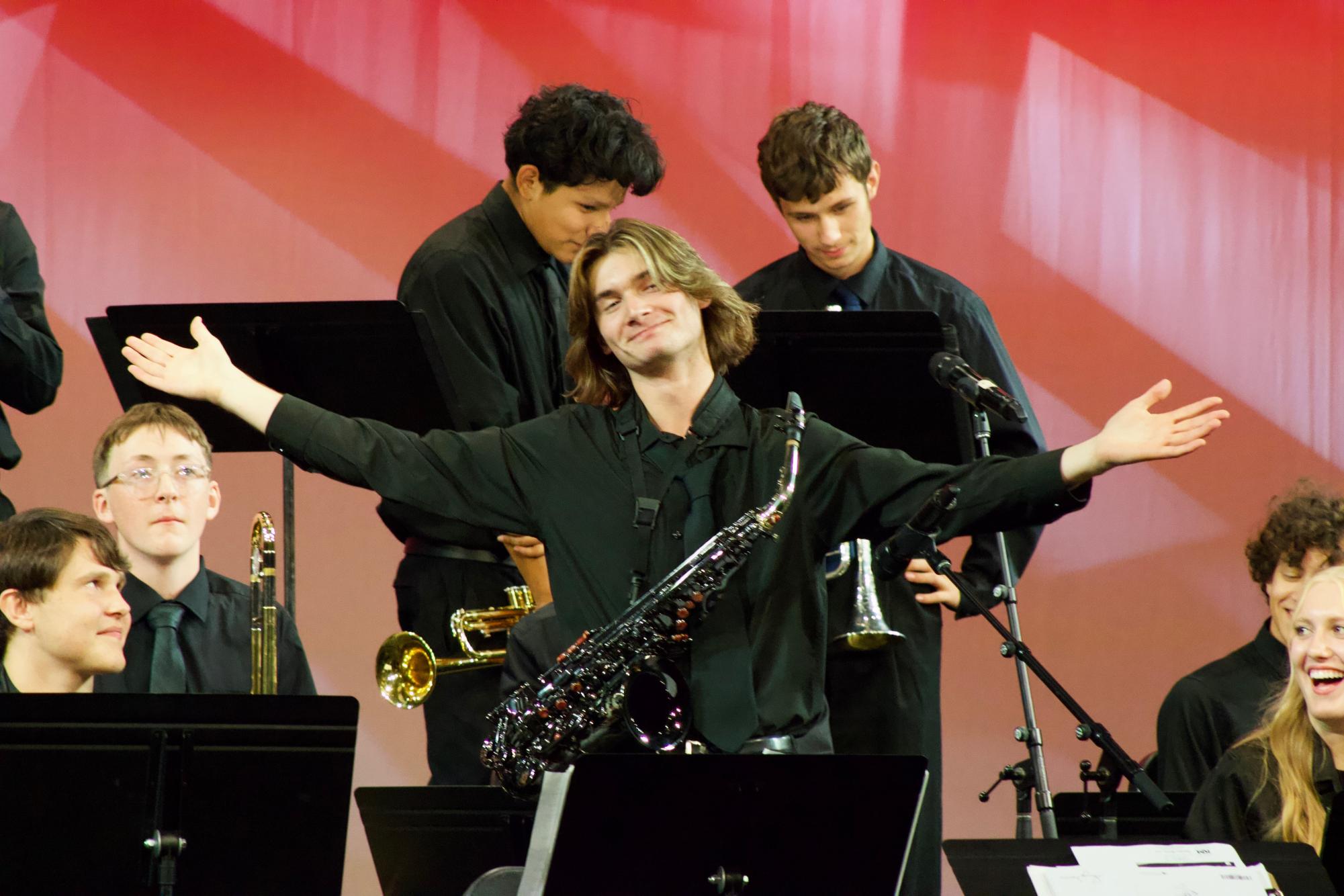 The audience finds its seats in the auditorium, anxiously awaiting the start of the concert. On stage, a group of musicians takes their places.