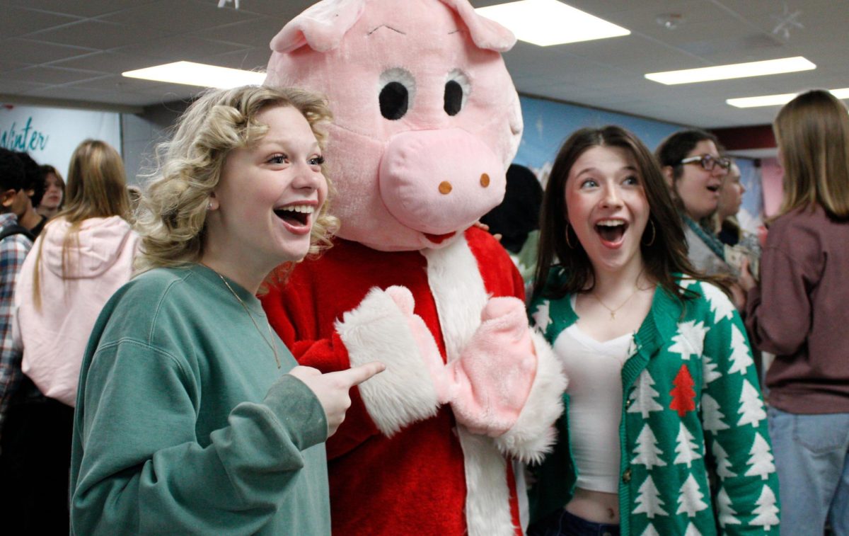 Lillian Davenport and Lillian Dinger smile wide for a picture with Swig the Pig.
