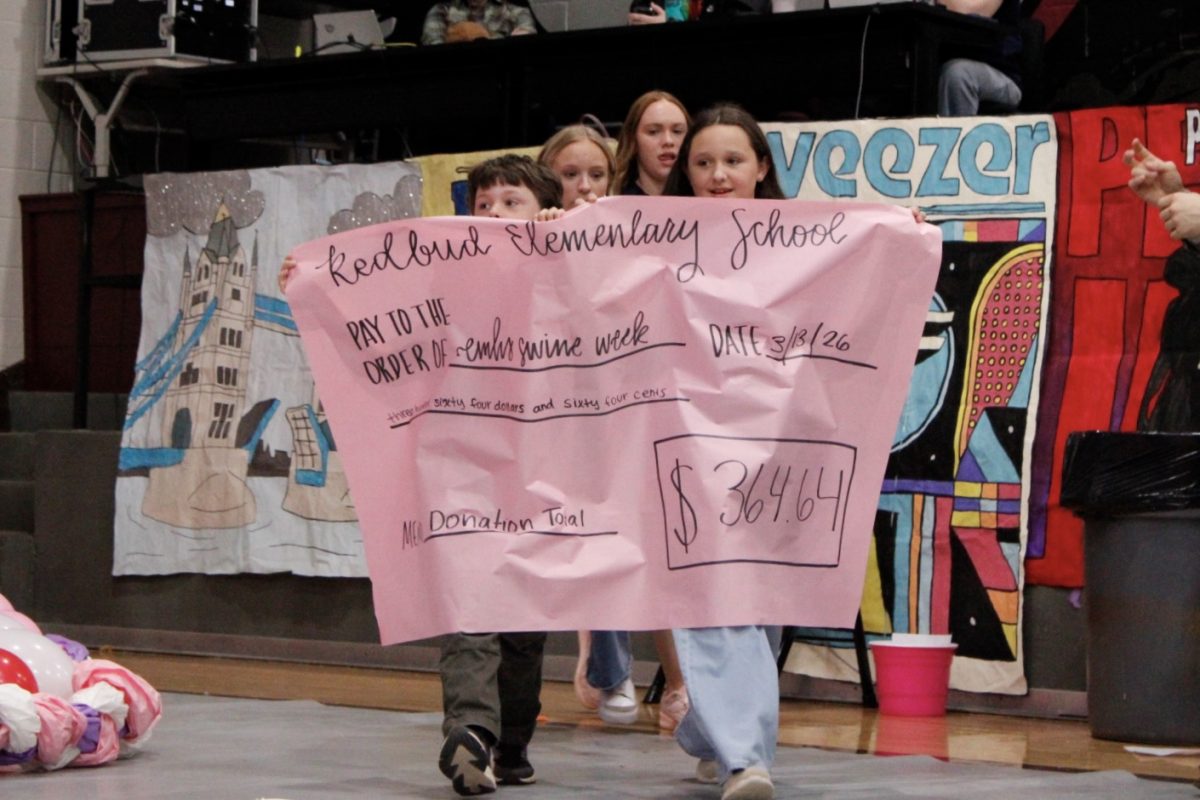 Students from Redbud Elementary present the total their school raised for Memorial's philanthropy week. 