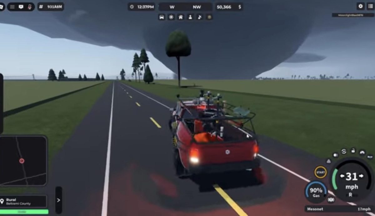 A wedge tornado condensing towards the ground in front of a tornado chasing truck.