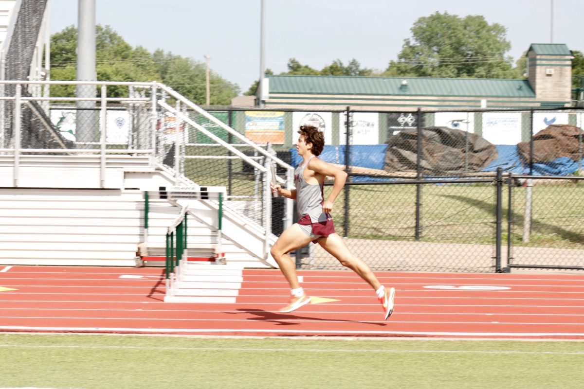 Sophomore Chase Whitaker runs as he tries to pass the baton to the other player.
