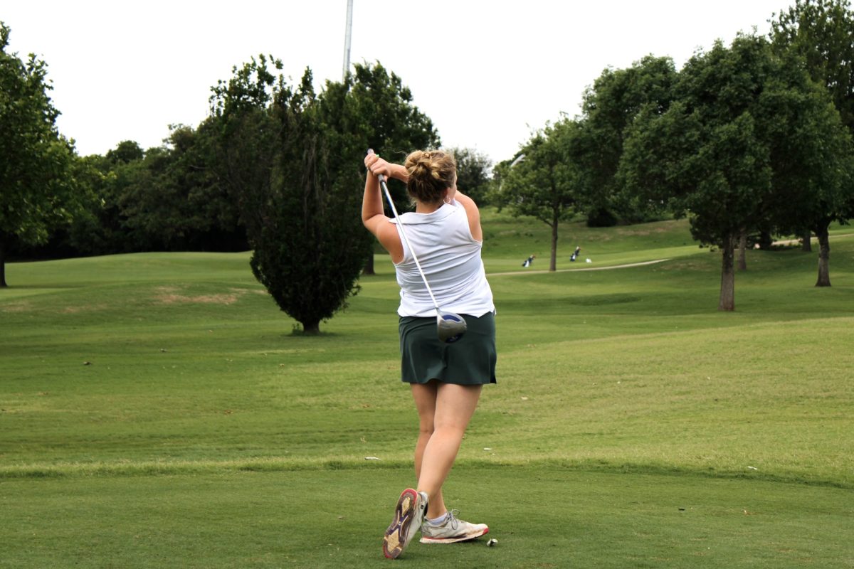 Freshman Kenzi Ketron hits the ball far beyond the trees.
