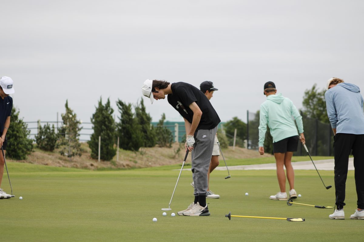 Senior Banks Manzer lines up his club to the ball to make it into the hole.
